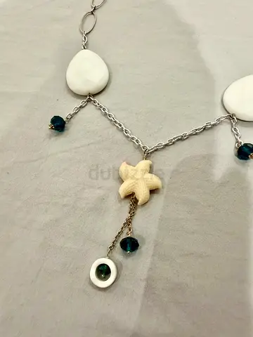 Silver-tone necklace with white beads and starfish charm, blue accents