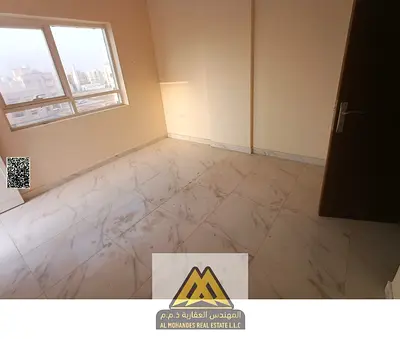 For rent: 2-bedroom apartment in Al Alia, Ajman, balcony, 2 bathrooms, central AC, free maintenance, on Sheikh Mohammed Bin Zayed Road, AED 39,000.