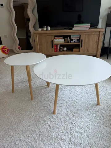 Set of 2 round white nesting coffee tables with wooden legs (can be sold separately)
