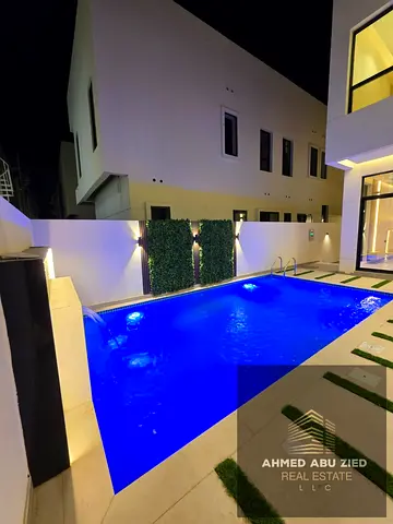 Luxury villa for annual rent in Al Helio - Ajman, 5 bedrooms, private pool, modern finishes, central AC, living room + majlis, spacious roof, Prime.