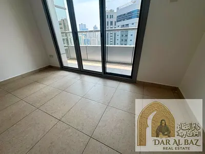Two-bedroom apartment with a living room for annual rent in Al Khan, featuring three bathrooms, a balcony with an open view, and a master bedroom. Eas