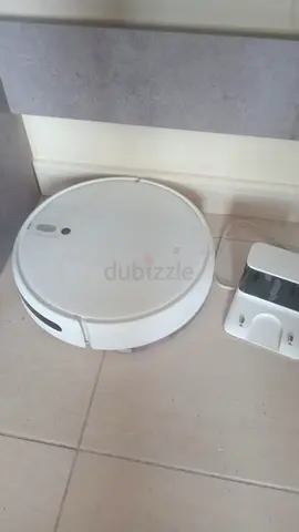 White robotic vacuum cleaner with charging dock - used but working