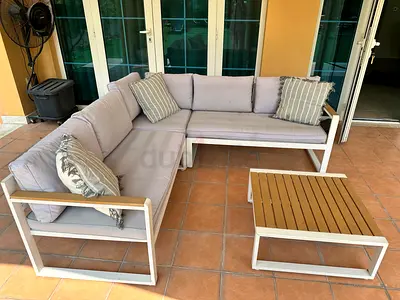 Outdoor L-shaped patio sofa set with cushions and coffee table