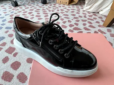 Black patent leather low-top sneakers with white sole