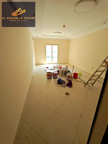 Two-bedroom apartment with a living room, balcony, and free parking for rent in Al Taawun.