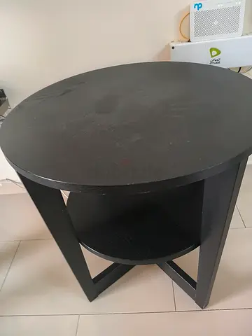 Round black wooden side table with lower shelf