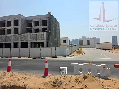 Commercial land for sale on the main street directly opposite Azha, with a large front extension, prime location, freehold ownership.