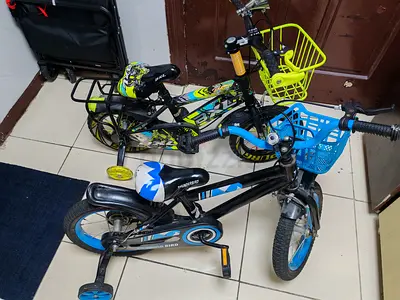 Two kids bicycles with training wheels and front baskets - good condition