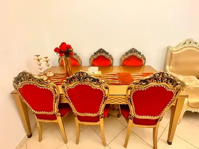 Classic gold dining table with 6 red velvet chairs - elegant set