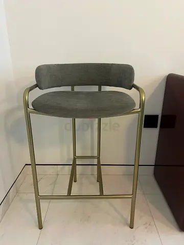 Modern brass-frame counter stool with grey upholstered seat and back