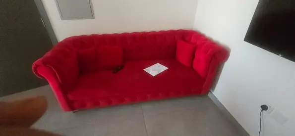 Red velvet Chesterfield-style 3-seater sofa in good condition