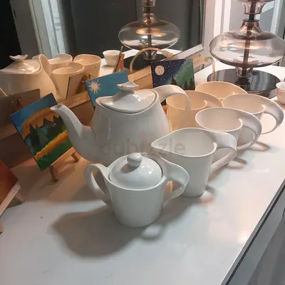 White ceramic tea set with teapot, cups and sugar bowl