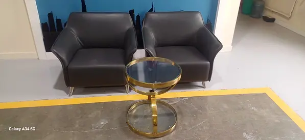 pair of black sofas with glass table