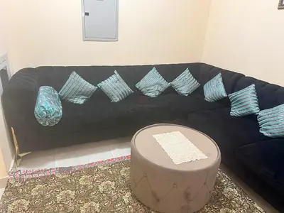 Large L-shaped Velvet Sofa with Cushions and Round Coffee Table