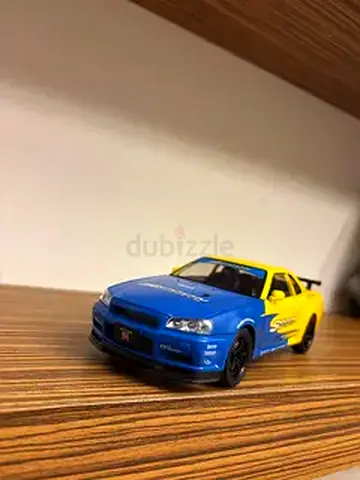 Die-cast Nissan Skyline R34 GT-R model car (blue/yellow) - 1:24 approx