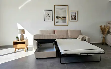 Modern living room sofa bed featuring a spacious chaise, large sleeping area, and convenient under-s