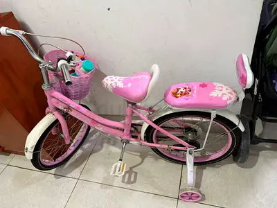 Kids pink bicycle with training wheels and basket - good condition