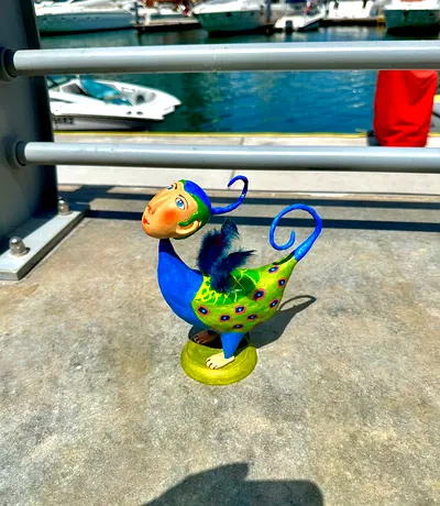 Hand-painted whimsical bird figurine with feather detail