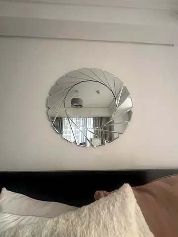 Round decorative wall mirror with spiral segmented design