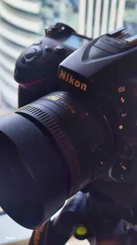 Used DSLR camera body with lens on tripod — good working condition