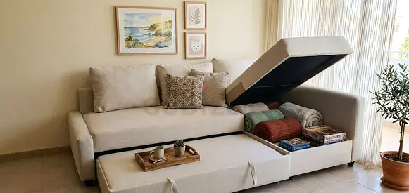 Stylish corner sofa bed with a large pull-out sleeping area and hidden storage compartment for blank