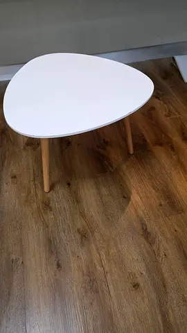 Small white triangular side table with wooden legs
