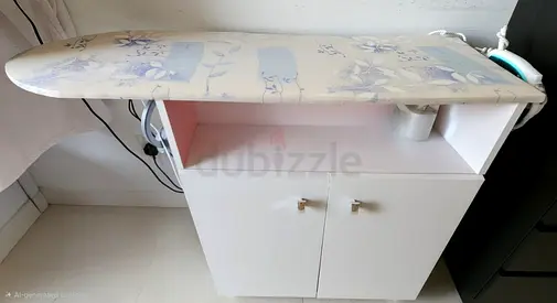 White cabinet with ironing board top — compact laundry storage
