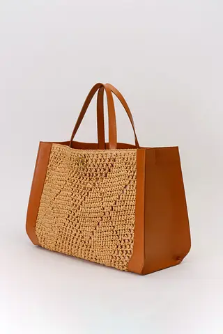 Brown woven raffia tote bag with genuine leather side panels and handle.