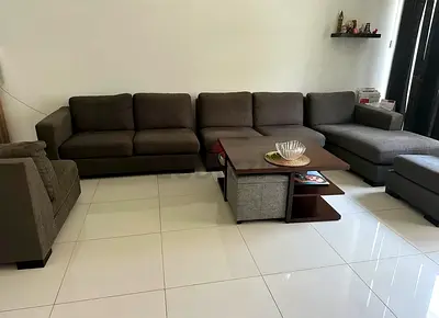 Large L-shaped grey fabric sectional sofa with chaise and single armchair