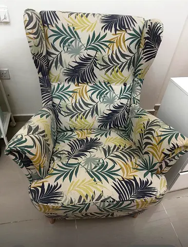 Comfortable wingback armchair with leaf-patterned upholstery