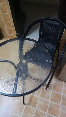 Glass-top bistro table with two rattan-style chairs - compact patio set