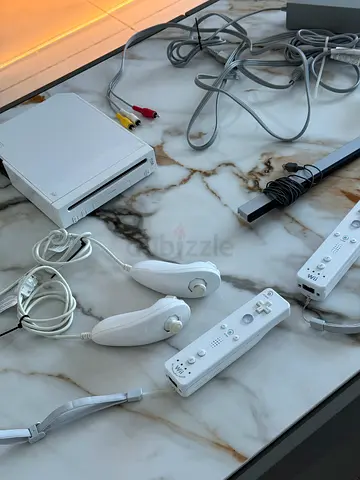 White Nintendo Wii console bundle with 2 remotes, nunchucks and fitness pad.