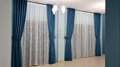 Blue, Brown/Grey blackout curtains with white lace sheers with rods.