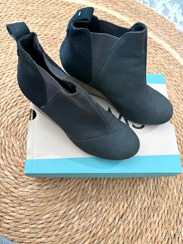TOMS Womens Kelsey slip-on ankle boots feature a black leather and suede finish
