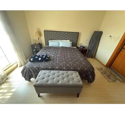 King size upholstered bed with tufted headboard and 6 drawer storage and 2 side table