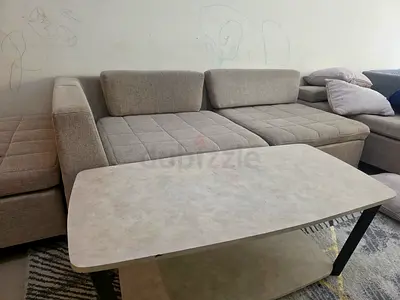 Light beige fabric sectional sofa with matching ottoman and coffee table only for 200 Aed