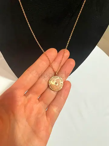 Gold-tone pendant necklace with stamped disc charm, worn condition