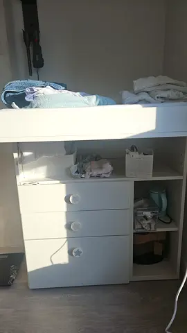 White nursery changing table with storage drawers and shelves
