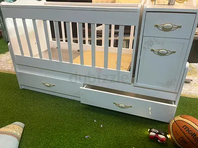 White convertible baby crib with built-in drawers and changing unit