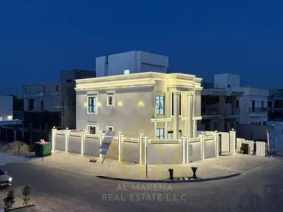 Corner villa for sale in Ajman, two floors and a roof terrace, situated on two streets with a large setback in a prime residential location near a mos