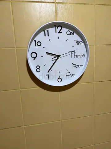 White wall clock with numerical and word markers - good condition