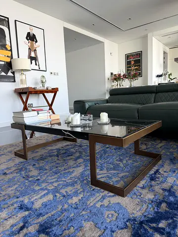 A low rectangular coffee table with a natural black marble top —
deep black with soft white veining