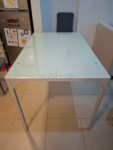 White glass top dining table with metal legs - modern design