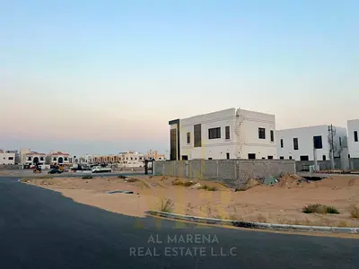 Two corner plots for sale in Al Yasmeen, Ajman, on the main road opposite Al Rahmaniya, Sharjah. The plots are 4,153 and 4,296 sq ft, with permits for