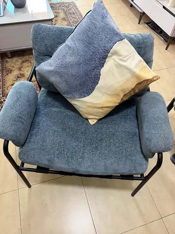 Single blue cushioned lounge chair with metal frame