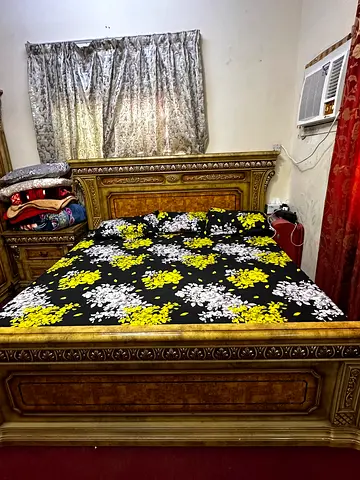 Solid wood king-size bed with ornate headboard and footboardk