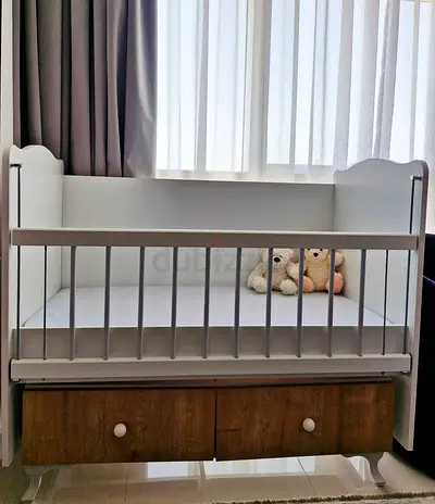White wooden baby crib with under-drawer storage - good condition