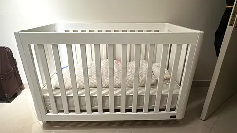 Adjustable White wooden baby crib in fair condition