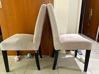 Brand: The one A Pair of beige upholstered dining chairs with black legs