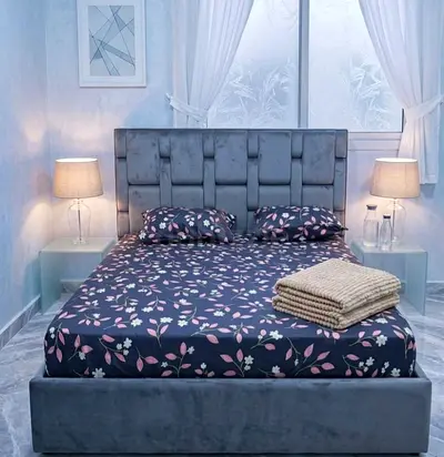 Grey upholstered double bed with padded headboard